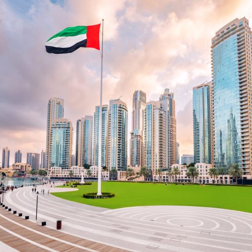 Scenic view of Dubai skyline, with the skyscraper buildings and national flag. Sightseeing and travel destinations in Arab Emirates